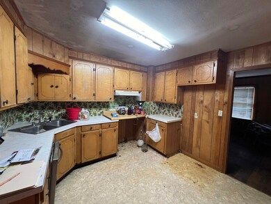 Kitchen with black dishwasher, a textured ceiling,
