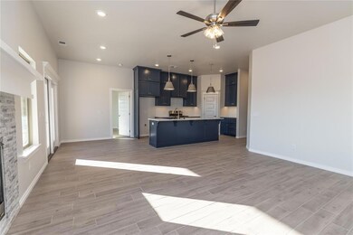 Kitchen featuring sink, a stone fireplace, light h