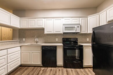 Kitchen with black appliances, light countertops,