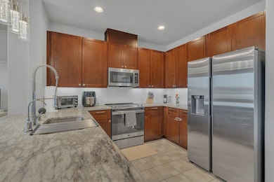 Kitchen featuring light stone countertops, backspl
