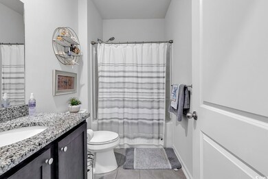 Full bathroom with shower / tub combo, light tile patterned floors, and vanity