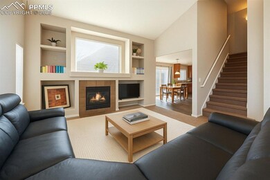 Living room with built in features, a fireplace, lofted ceiling, stairs, and baseboards
