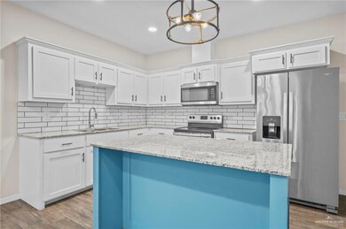 Kitchen with wood-type flooring, appliances with stainless steel finishes, sink, and white cabinetry