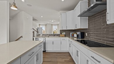 Gourmet kitchen with quartz counter tops, electric cooktop and vented hood, by DRB Homes Charlotte, NC