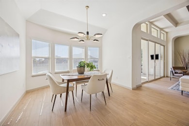 Dining area with light wood finished floors, recessed lighting, arched walkways, and a chandelier
