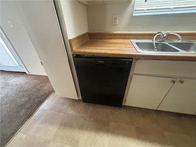 Kitchen featuring black dishwasher, light colored 