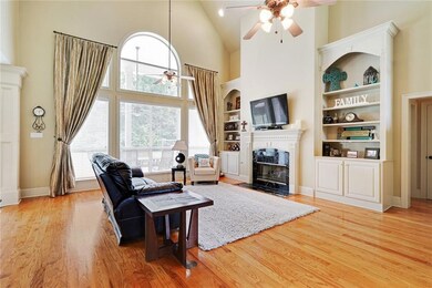 Den overlooks rear yard.  Built-ins and fireplace