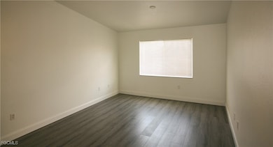 Spare room with dark wood finished floors and base