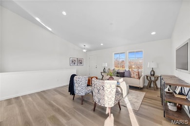 Living area with recessed lighting, vaulted ceiling, and light wood finished floors