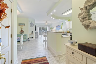 Hall with marble finish floor, crown molding, and recessed lighting
