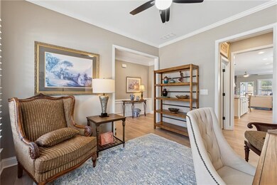 Sitting room with light wood-style flooring, a cei