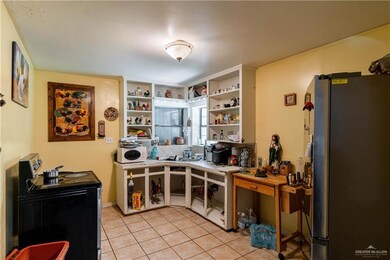 Kitchen featuring light tile patterned flooring, electric range, and stainless steel fridge