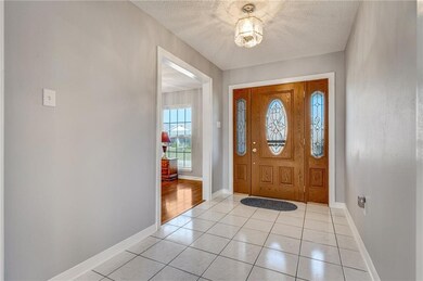 Welcoming tile foyer and beautiful front door.  Fo