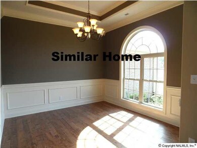 Dining room with 10 foot ceilings plus a trey ceiling, hardwood floors, shadow boxes with chair rail. Picture from similar home.