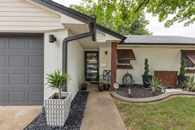 Property entrance with a garage, brick siding, and a shingled roof