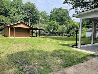 View of yard featuring a detached garage, an outdoor structure, and driveway