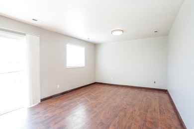 Empty room featuring wood finished floors and baseboards