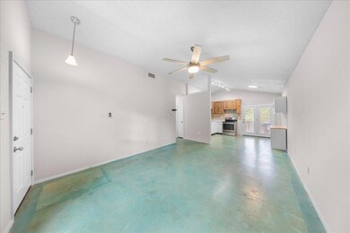 Unfurnished living room featuring vaulted ceiling