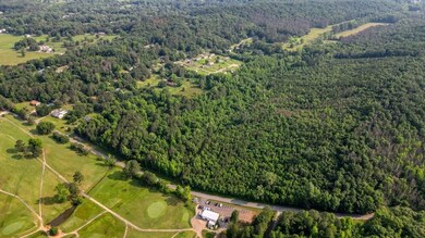 Aerial view of property and surrounding area with a heavily wooded area