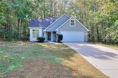 View of front of home featuring concrete driveway and a front lawn