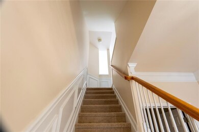 Staircase featuring a decorative wall and wainscot