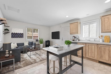 Kitchen opens to lving room with recessed lighting, open floor plan. and cozy pellet stove. (Virtually Staged)