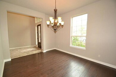 Dining room dazzled by hardwood floors, handsome hanging light fixture and access to the kitchen.