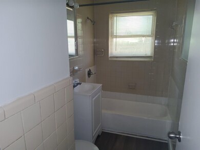 Full bathroom with tiled shower / bath combo, toil