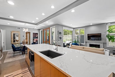 Kitchen featuring light stone counters, open floo
