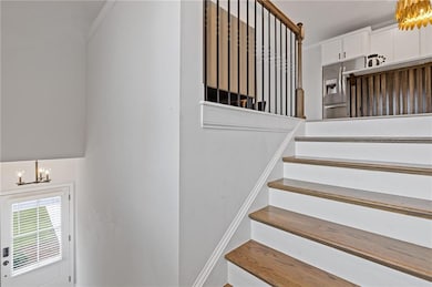 Stairway with a chandelier and ornamental molding