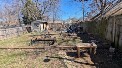 View of yard with an outbuilding, a shed, and a fe
