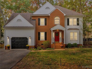 Colonial house with a front lawn and a garage