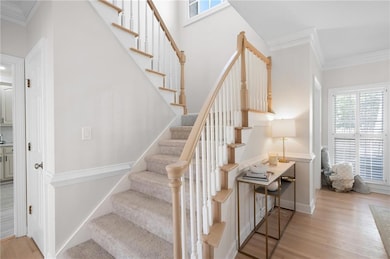 Staircase with baseboards, ornamental molding, and