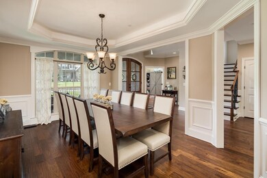 Formal dining room with inset lighting in trey ceiling, wainscoting and beautiful natural light 