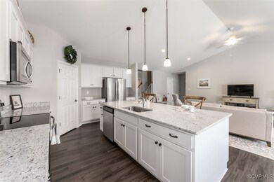 Kitchen featuring white cabinetry, light stone cou