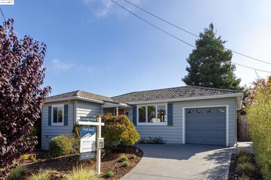 Ranch-style home featuring a tiled roof, driveway, and a garage
