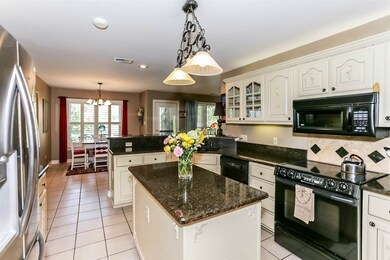 Spacious kitchen features granite countertops, cab