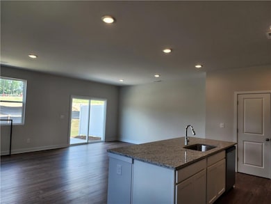 Kitchen with a sink, stone countertops, dishwasher