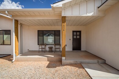 Property entrance featuring stucco siding and covered porch