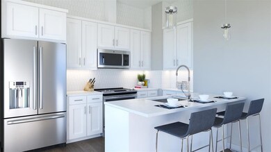 Kitchen with white cabinets, a breakfast bar, a s