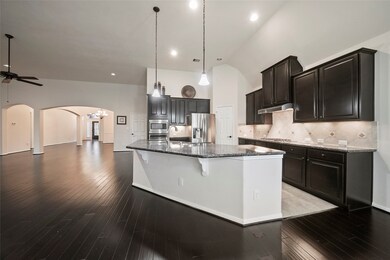 Plenty of seating at the breakfast bar in this gorgeous kitchen with pendant lighting, stainless appliances and soaring ceilings