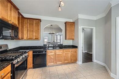 Kitchen with light tile patterned floors, a sink, 
