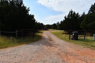 View of dirt / gravel road featuring a view of trees
