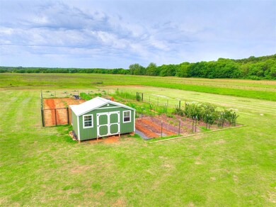 View of yard with a rural view, a storage unit, an