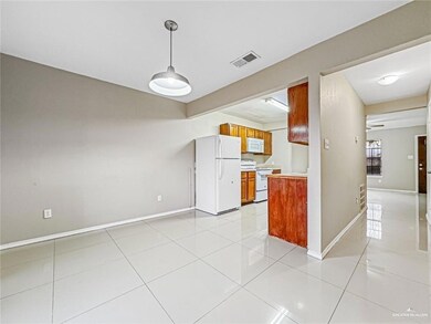 Kitchen with white appliances, pendant lighting, and light tile patterned flooring