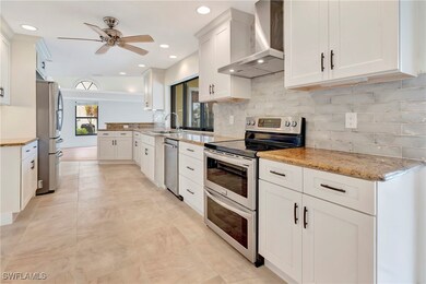 Kitchen featuring wall chimney range hood, applian