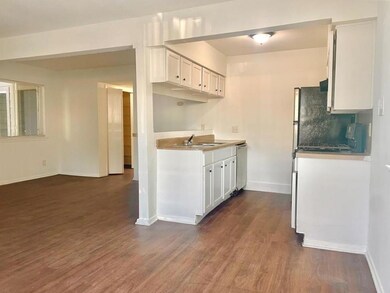 Kitchen featuring baseboards, dark wood-style flo