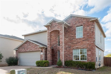 Traditional-style house featuring brick siding and concrete driveway