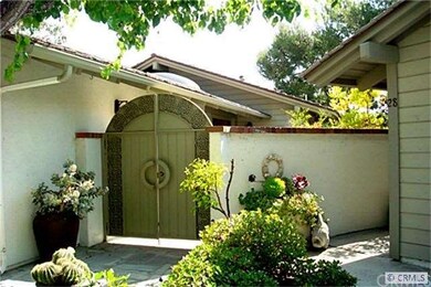 Ornate entry gate leads to charming patio.