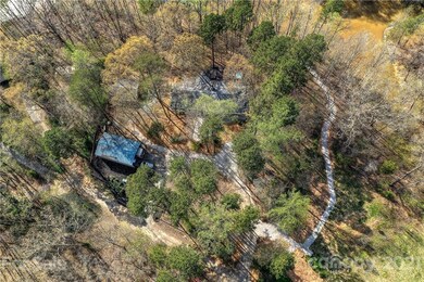 Aerial showing oversized outbuilding, detached two car garage and part of lake.